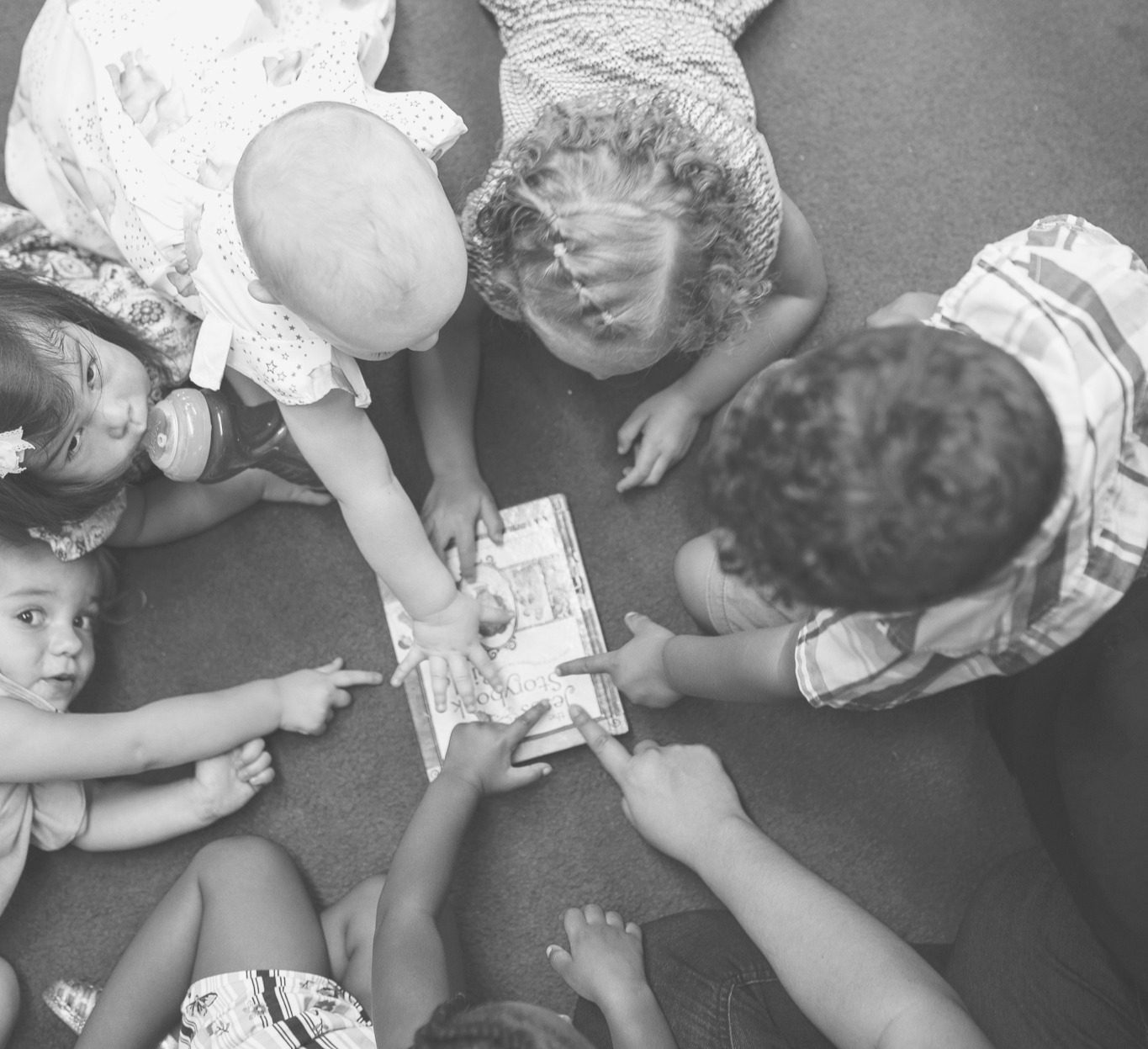 Children at Crossings Kids gathering around a storybook